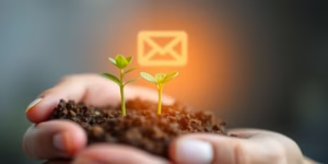 Seedling growing in hand over glowing email icon.